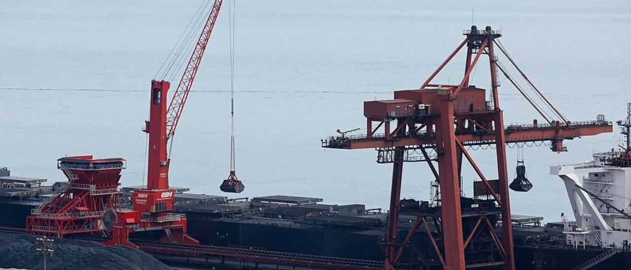 Uno de los dos pórticos y la grúa con tolva ecológica de Ebhisa descargan un granelero en la terminal.