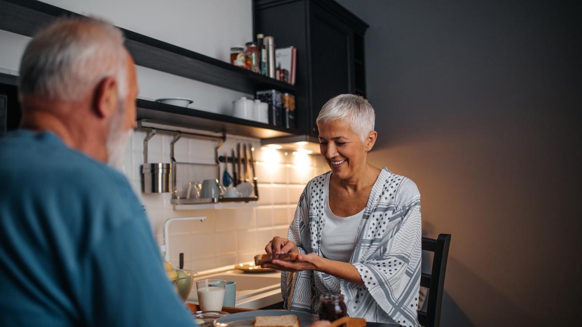 Una pareja de personas mayores charla en la cocina