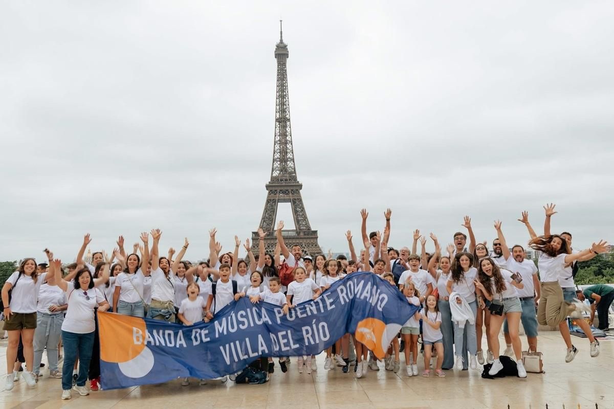 Los integrantes de la banda de música Puente Romano de Villa del Río ante la Torre Eiffel.