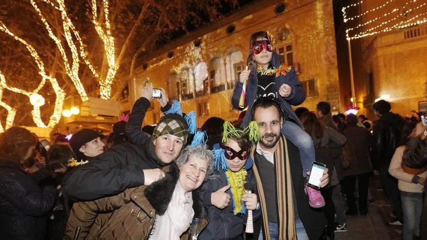 Una familia celebra la fiesta de Nochevieja en la plaza de las Tortugas, con el Solleric al fondo.