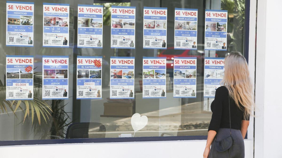 Una mujer mirando la oferta de una inmobiliaria en Alicante.