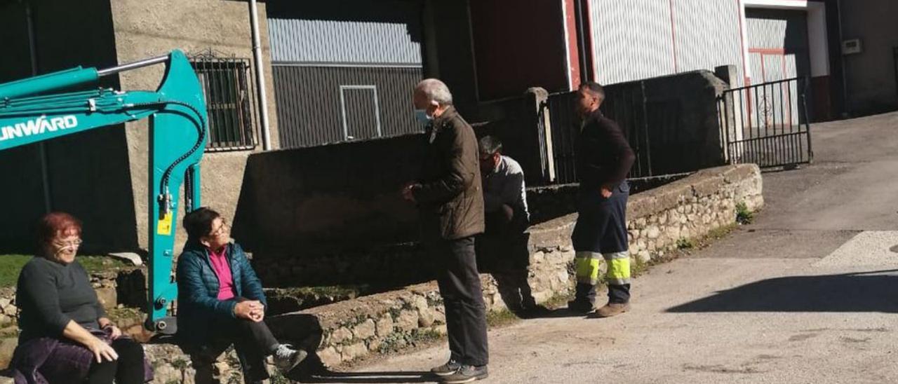 Vecinos de Tielve, junto a la maquinaria para la obra. | M. V.