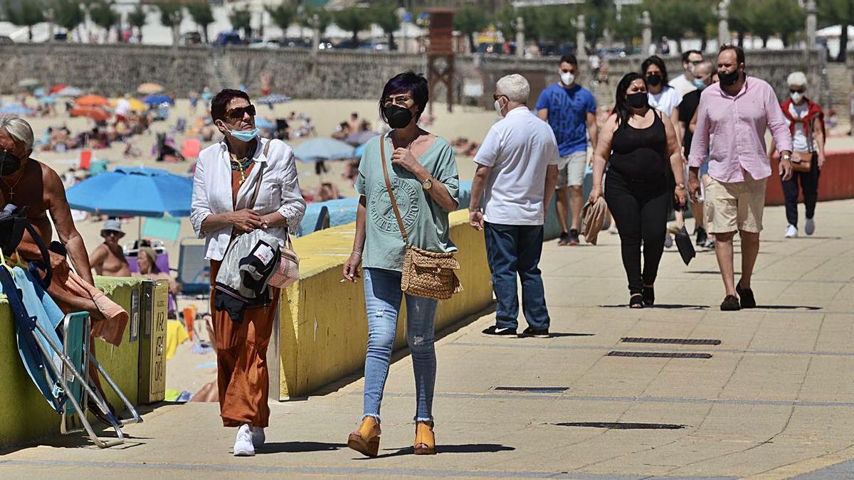 Animado ambiente en el paseo de Silgar, con la playa llena.