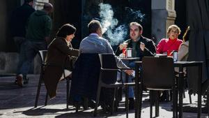 Clientes fumando en una terraza.