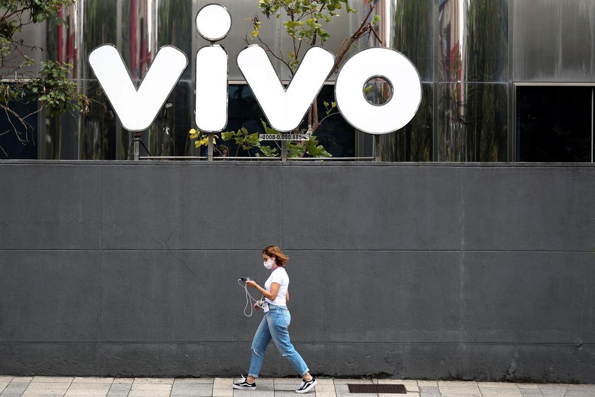 Una persona pasa frente a la sede de Vivo en Sao Paulo, filial de Telefónica en Brasil.