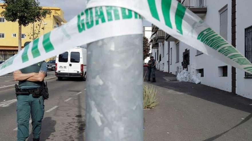 Agentes de la Guardia Civil, tras el cordón establecido ante la vivienda donde se produjo el crimen.