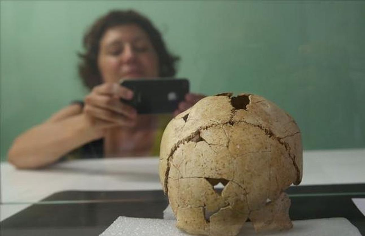 Una dona fa una foto del crani trobat a Banyoles. Una dona fa una foto del crani trobat a Banyoles.