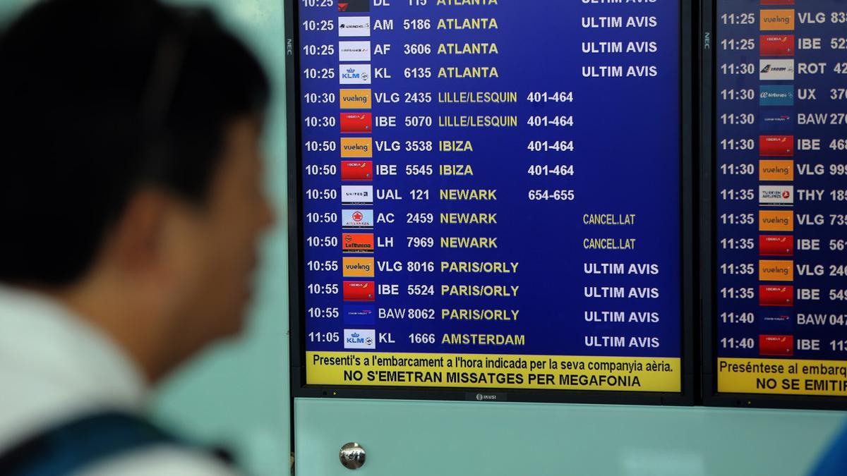 Un viajero consulta la programación de vuelos en el aeropuerto de Barcelona a principios de Julio.