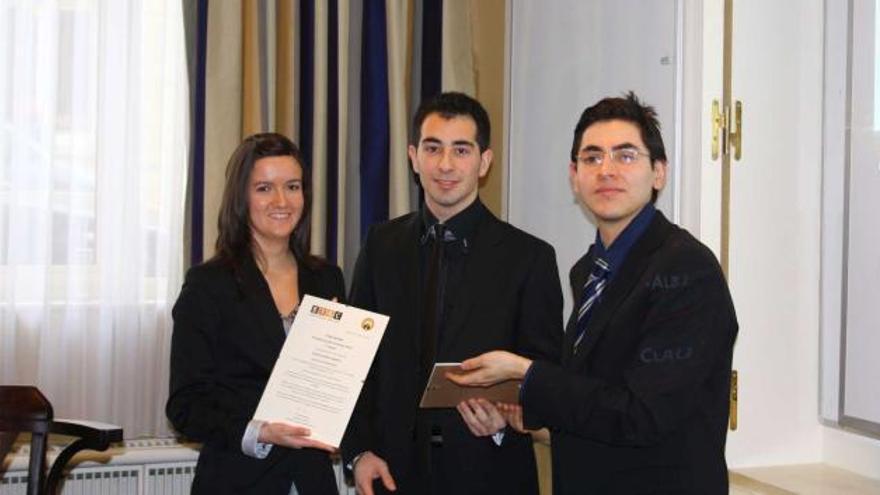 Por la izquierda, Claudia Alonso y Alberto Martínez reciben el premio de manos de uno de los miembros del jurado.