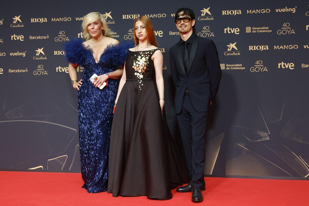 La directora de comunicación de RTVE María Izaguirre (i) junto a los cantantes Tony y Luci, ganadores del Benidorm Fest, posa en la alfombra roja de los Premios Goya.