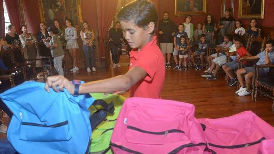 Un niño recoge una mochila en la recepción de 2017 en el Concello de Vilagarcía. // Noé Parga