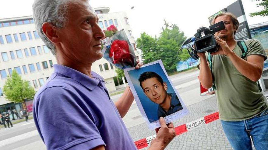 Un home mostra una fotografia del seu fill, que va morir assassinat en l&#039;assalt al centre comercial