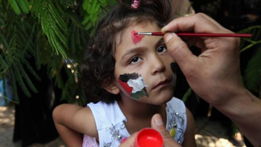 Una niña palestina, con el rostro con los colores de su país.