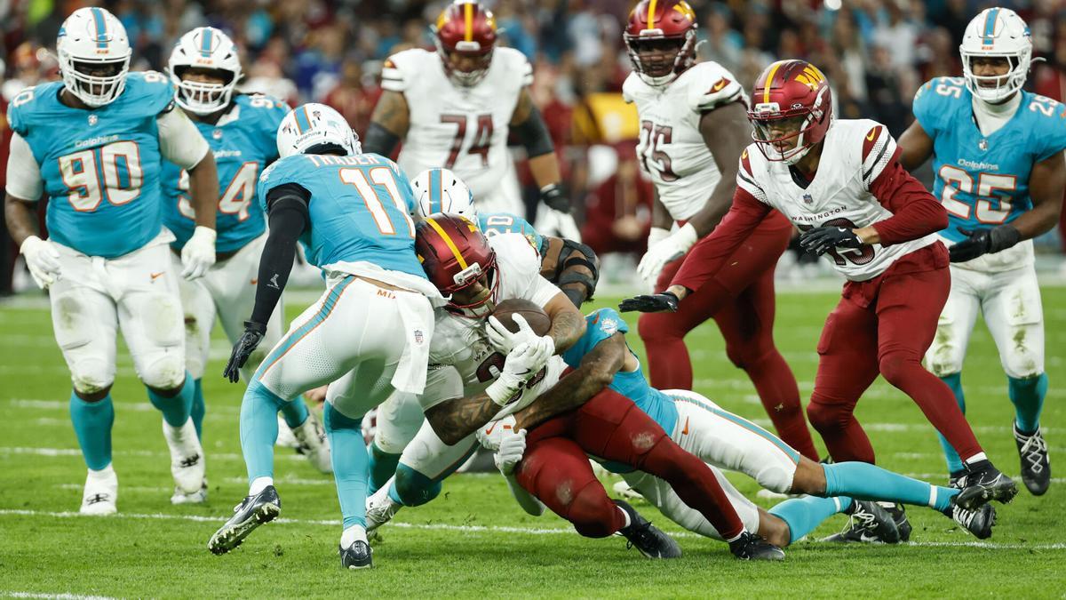 El jugador del Miami Dolphins Chris Rodriguez Jr (c), y el jugador de los Miami Dolphins JuJu Brents (c, detrás), durante el partido.