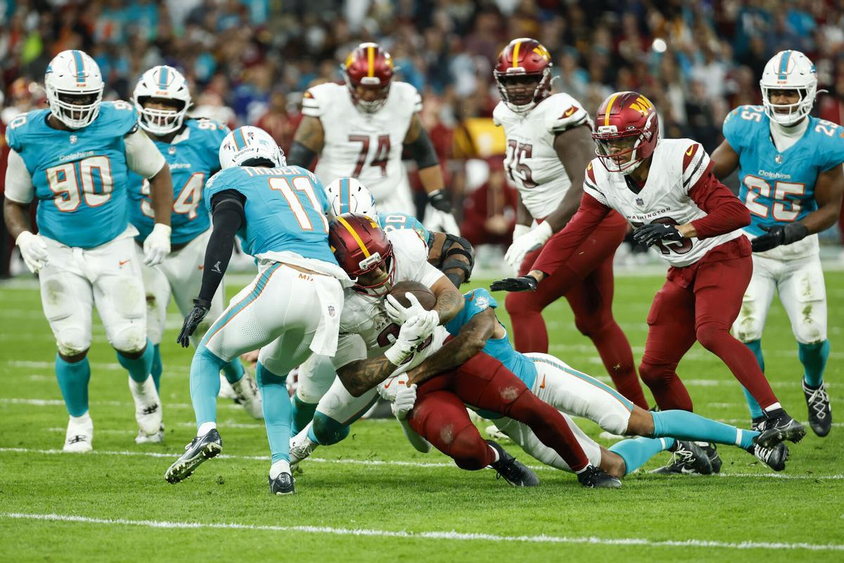 El jugador del Miami Dolphins Chris Rodriguez Jr (c), y el jugador de los Miami Dolphins JuJu Brents (c, detrás), durante el partido.
