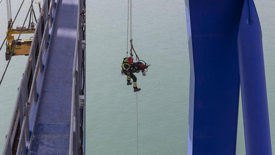 Los bomberos del Grupo de Trabajo y Rescate en Altura de València realizan un simulacro de rescate de un operario en la cabina de una grúa portuaria