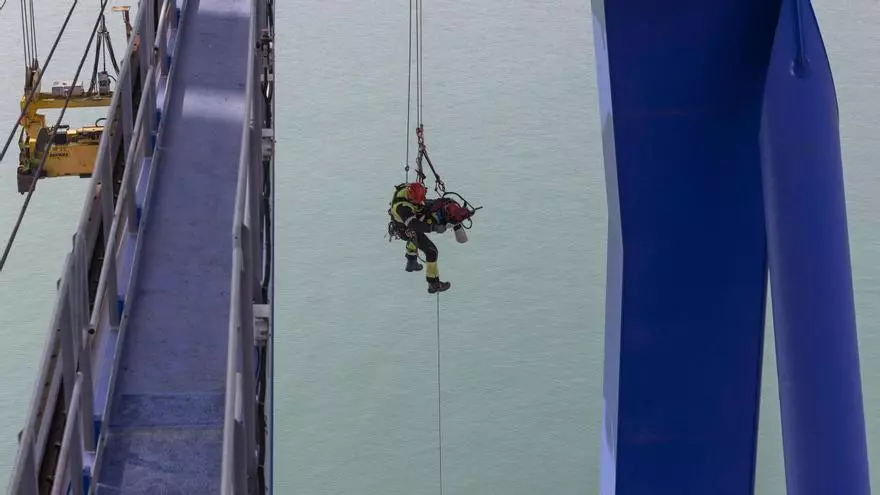 Los bomberos del Grupo de Trabajo y Rescate en Altura de València realizan un simulacro de rescate de un operario en la cabina de una grúa portuaria