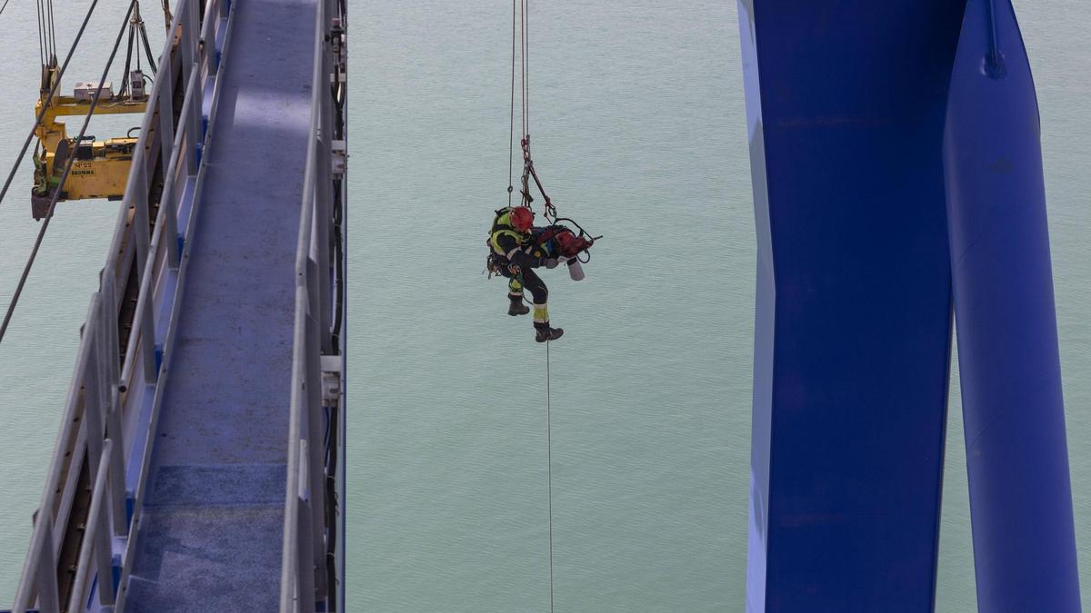 Los bomberos del Grupo de Trabajo y Rescate en Altura de València realizan un simulacro de rescate de un operario en la cabina de una grúa portuaria