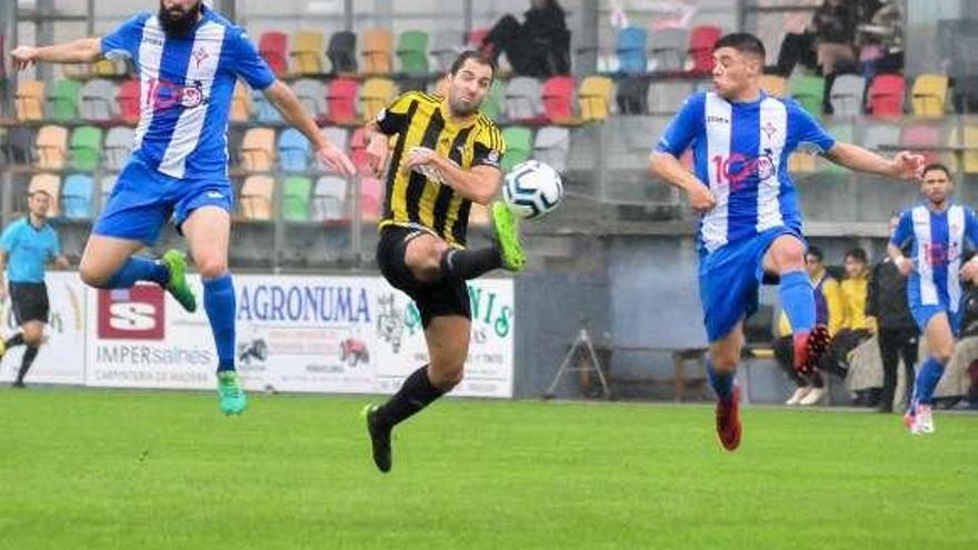 Fran Fandiño dispara a puerta ante la oposición de dos rivales. // I. A.