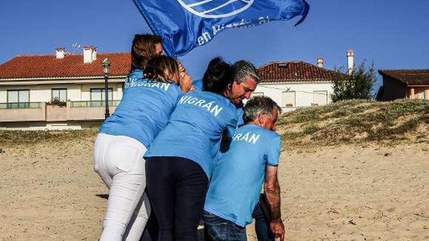 Abal y su equipo recrean la histórica instantánea de marines de EE UU en Iwo Jima en 1945 con una bandera azul en Praia América. // PP