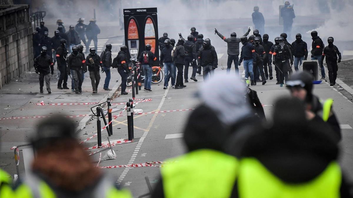 'Chalecos amarillos' se enfrentan a policías franceses en París el pasado sábado.