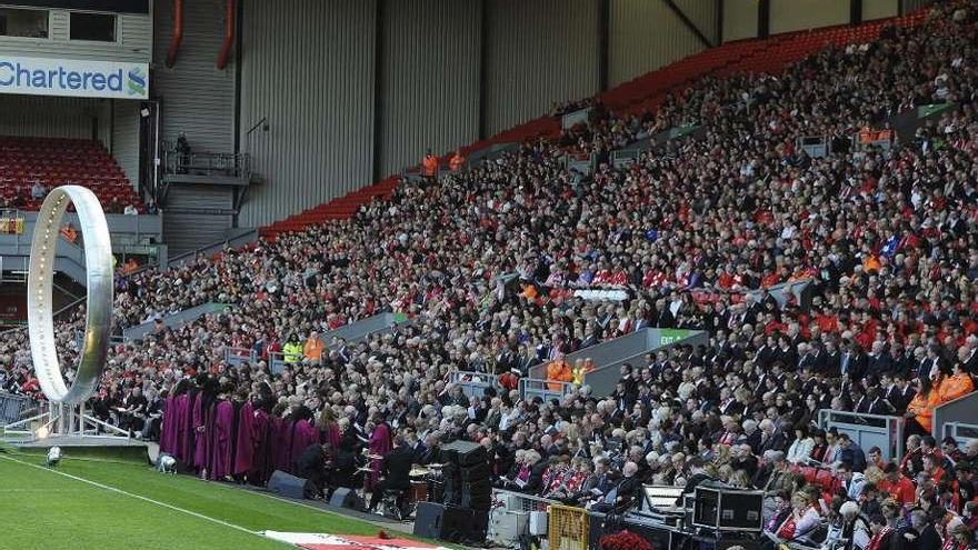 Arriba, la grada de Anfield. Sobre estas líneas Gerard con gesto de pesadumbre. A la izquierda, los regalos que los aficionados han dejado en el memorial. // Reuters