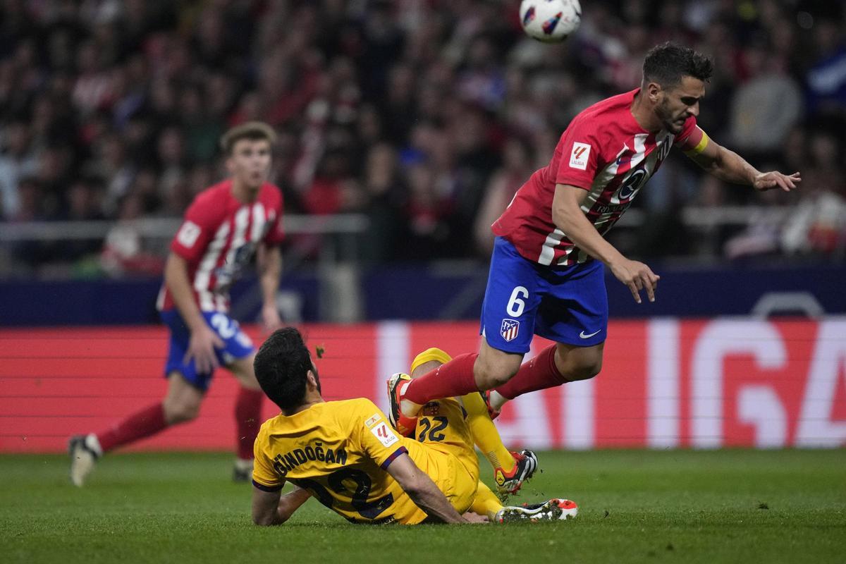 Koke Resurrección, jugador del Atlético, recibe una entrada de İlkay Gündoğan, del Barça, en el duelo del Metropolitano.