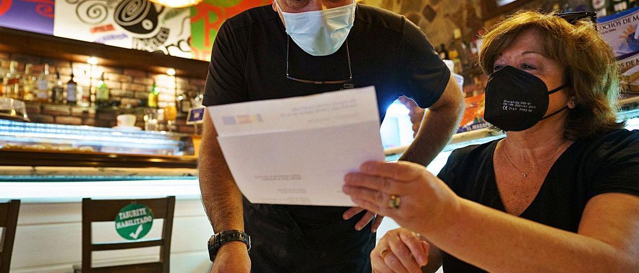 Una mujer muestra su certificado covid en el interior de una cafetería. | | EFE / RAMÓN DE LA ROCHA