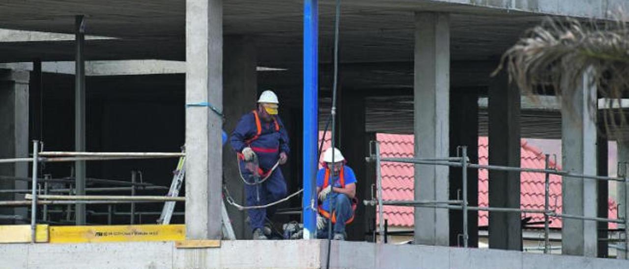 Dos operarios trabajan en la construcción de un edificio en el municipio de Gáldar.