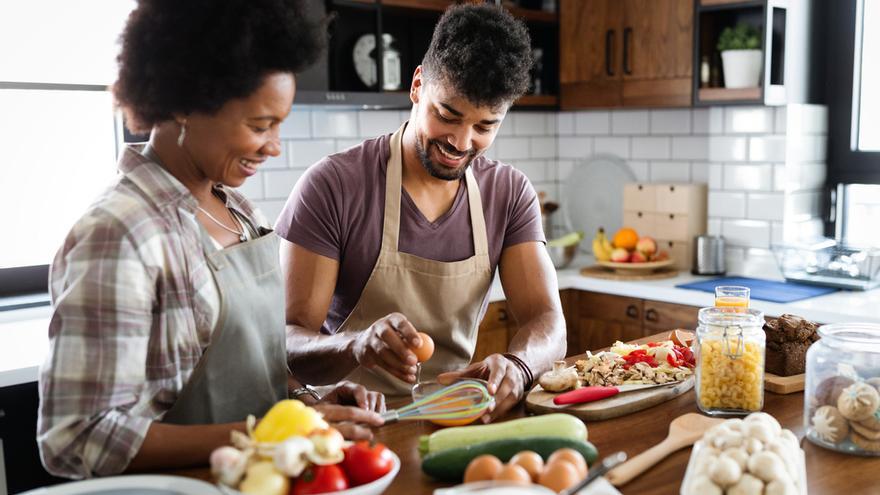 Una pareja cocina en su casa.