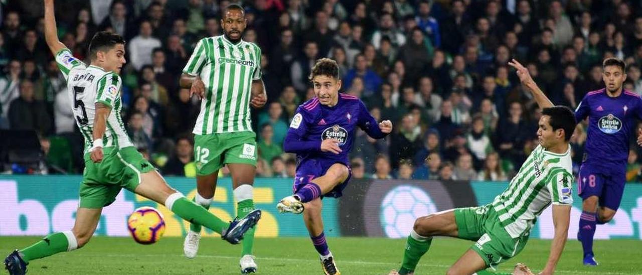 Emre Mor lanza a la portería del Betis rodeado de jugadores rivales durante el partido de Liga disputado anoche en el Benito Villamarín. // LOF