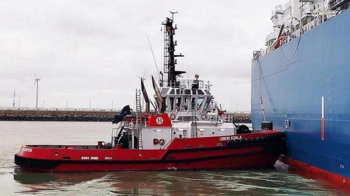 Un remolcador de Boluda Towage presta servicios a  una carguero en un puerto africano.