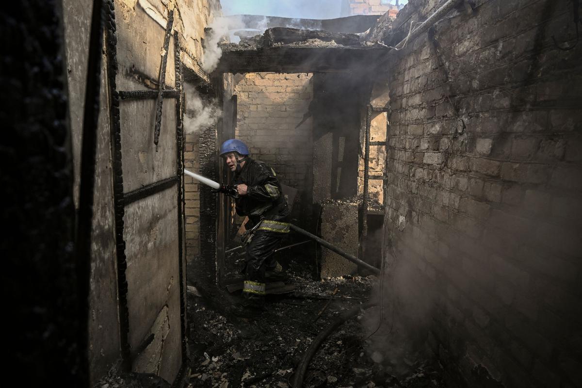 Un bombero apaga una casa en llamas alcanzada por cohetes Grad rusos en el distrito Shevchenkivsky de Kiev. Por primera vez hay señales de que las fuerzas ucranianas están pasando a la ofensiva, retomando una ciudad cerca de Kiev y atacando a las fuerzas rusas en el sur del país.