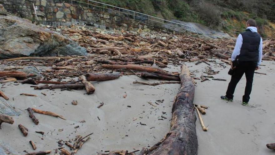 La playa de Arnao, llena de maderos por el temporal