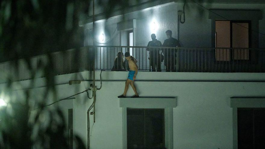 Un migrante desesperado amaga con tirarse desde un balcón en el campamento de Las Raíces.