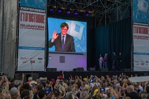 Carles Puigdemont comparece en pantalla durante la manifestación para conmemorar el quinto aniversario del referéndum del 1-O en Barcelona.