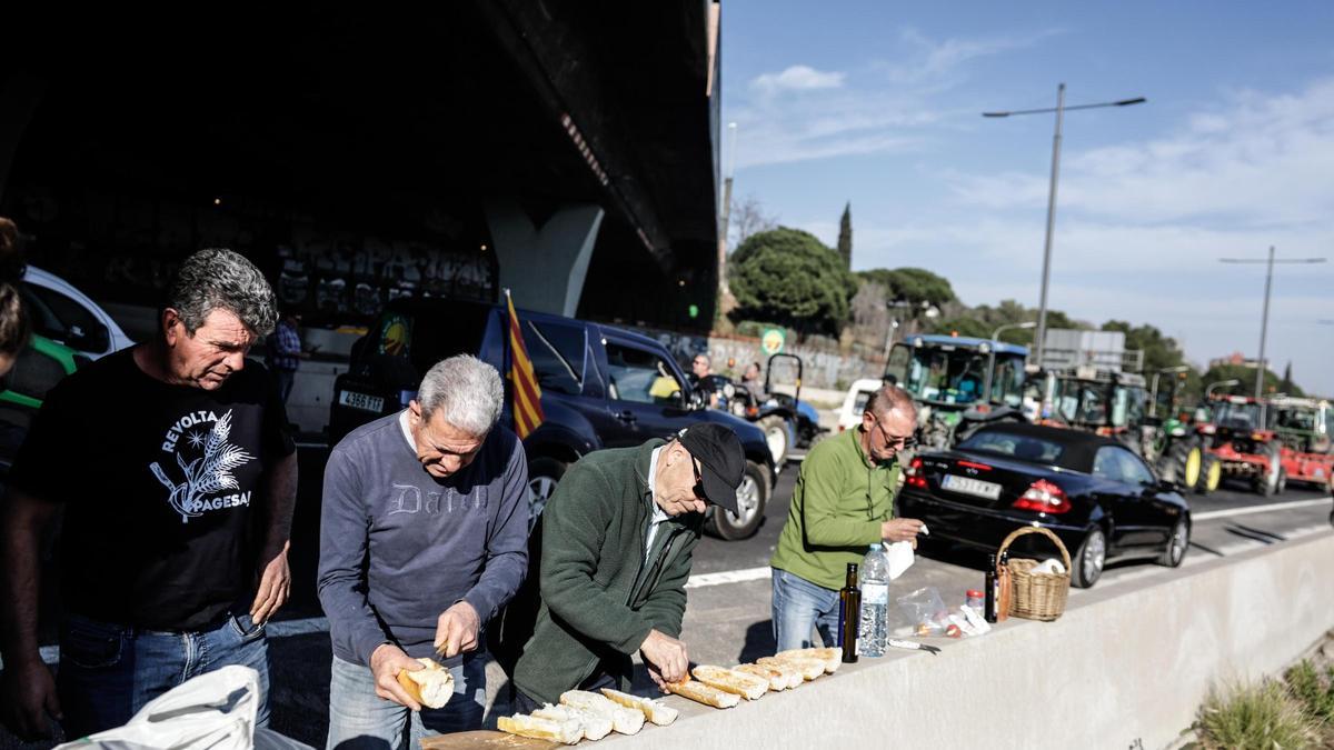 Agricultores preparan comida en la Diagonal, a su llegada a Barcelona.