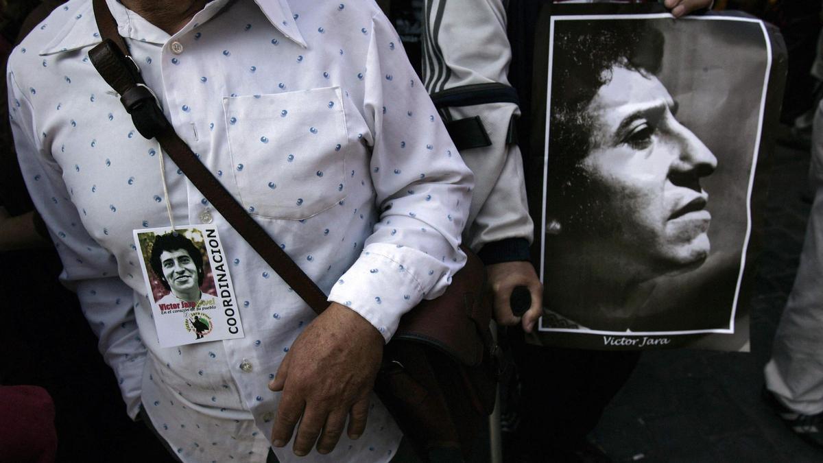 Un seguidor porta una imagen en recuerdo a Victor Jara.