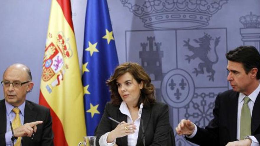 De izquierda a derecha, Cristóbal Montoro, Soraya Sáenz de Santamaría y José Manuel Soria.