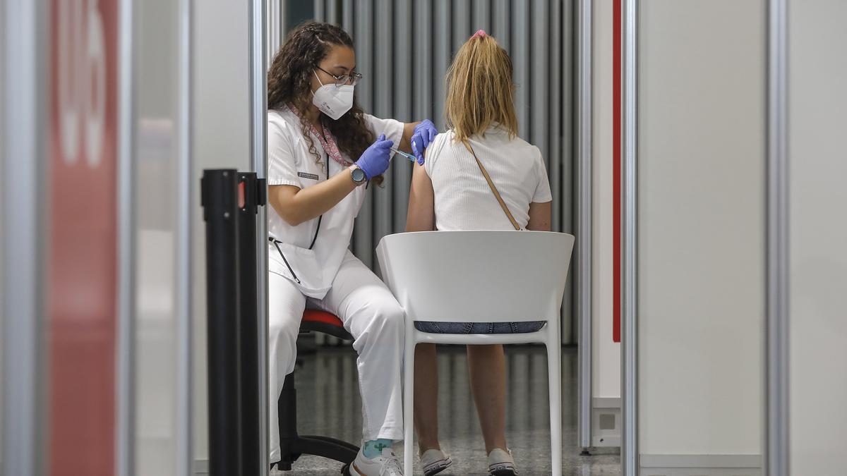 Una joven recibe la vacuna contra el covid.