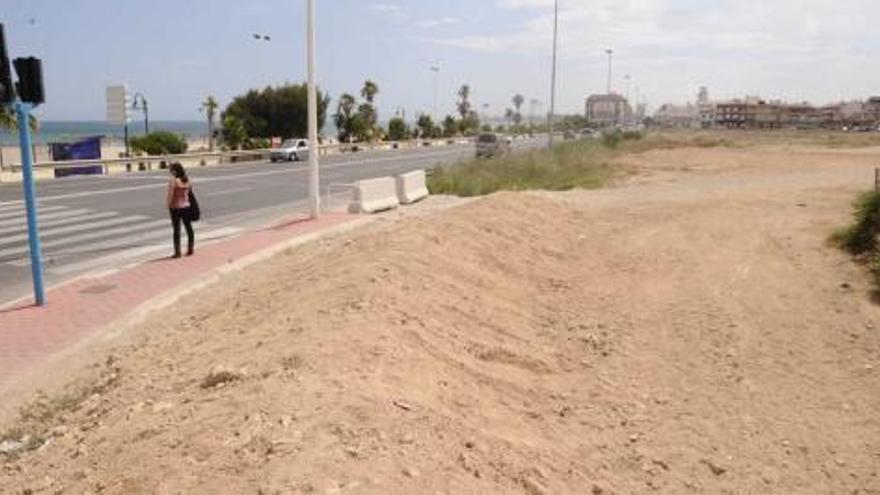 La parcela que se usaba como aparcamiento, hasta que los dueños la han rodeado con un montículo de tierra que impide el acceso a coches.