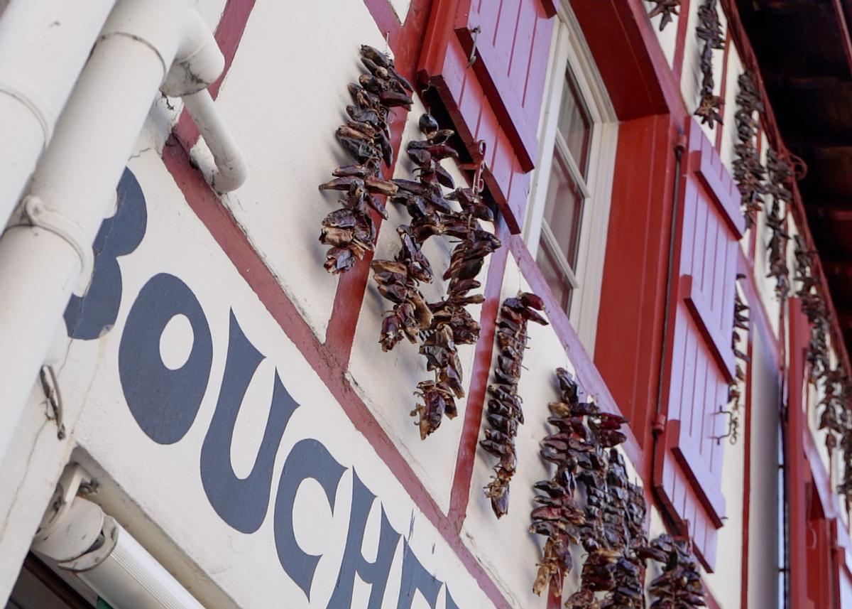 Ristras de pimientos de Espelette secándose al sol en la fachada de una casa del País Vasco francés
