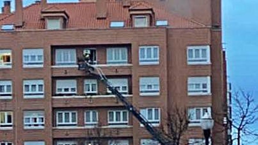 Los bomberos, ayer, entrando por la ventana del piso.