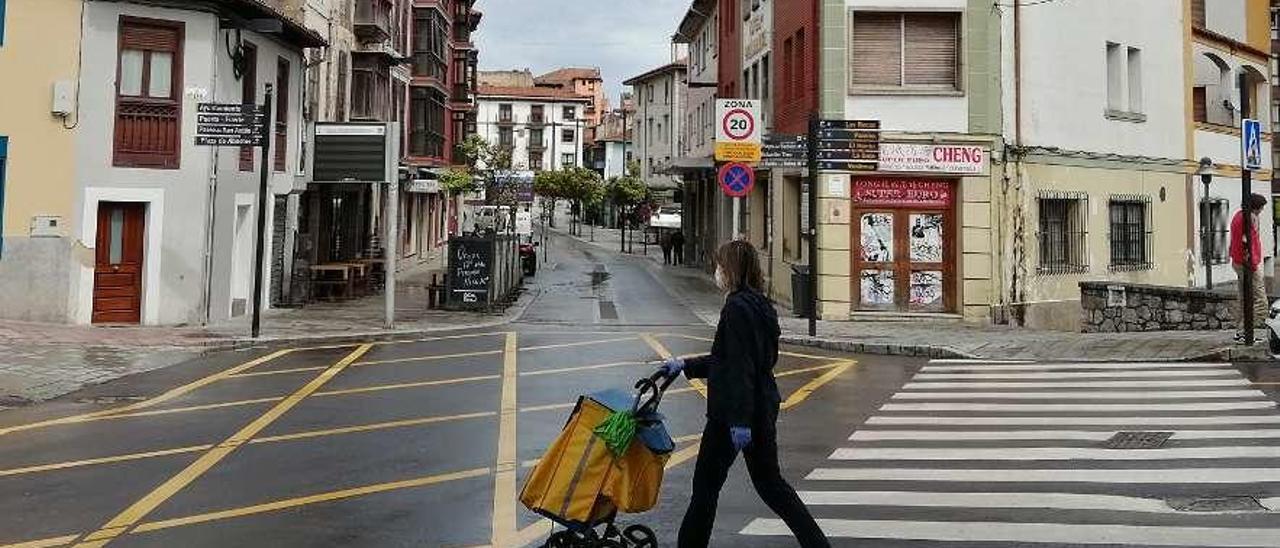 Una cartera cruza la calle en el inicio de la travesía semipeatonal de Llanes.