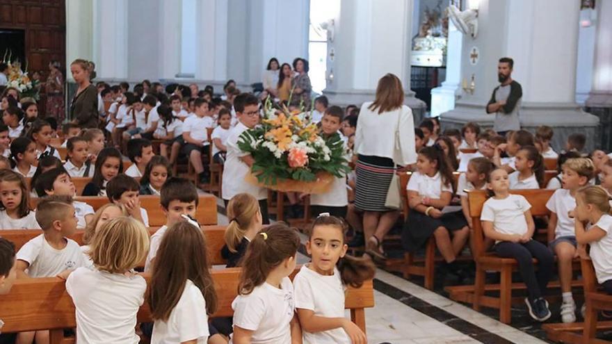 Los escolares realizan su ofrenda floral a la Virgen del Rosario