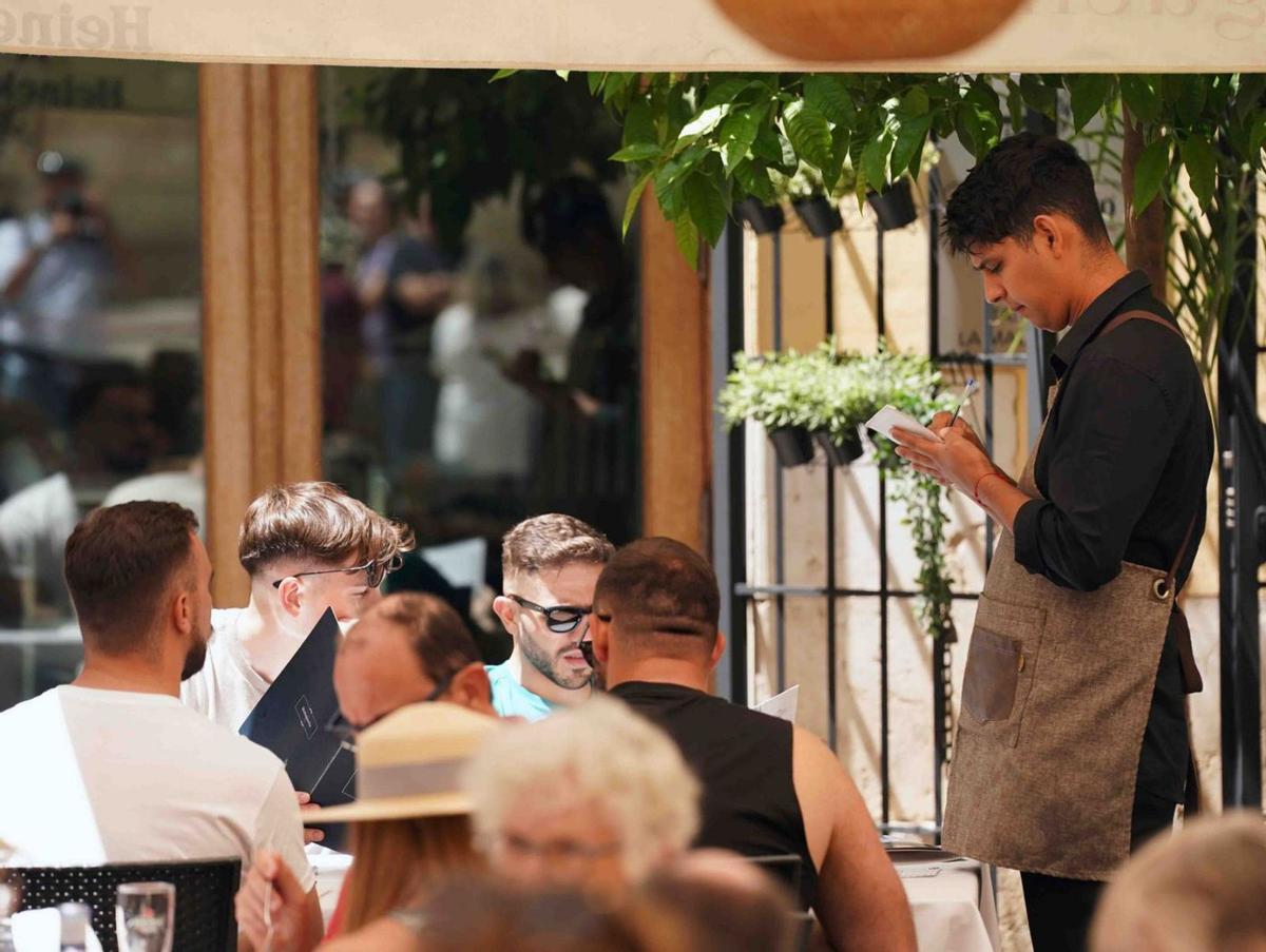 Un camarero atiende a los clientes en un establecimiento de Málaga. | ÁLEX ZEA