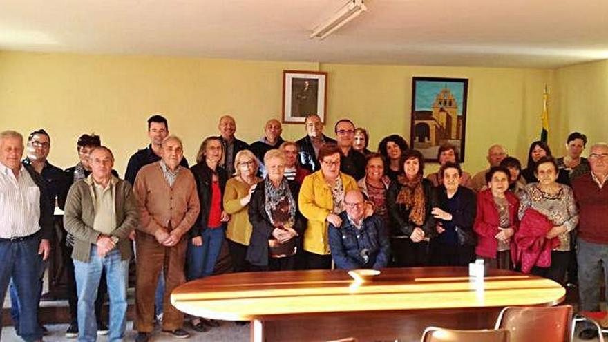 Varios vecinos se hacen una foto con el secretario, sentado en el centro.