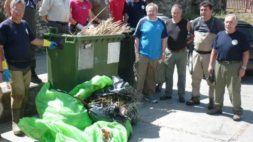 Voluntarios de las asociaciones de pescadores &quot;Fuentes del Narcea&quot; y &quot;El Banzao&quot;, con parte de la basura recogida en el río.