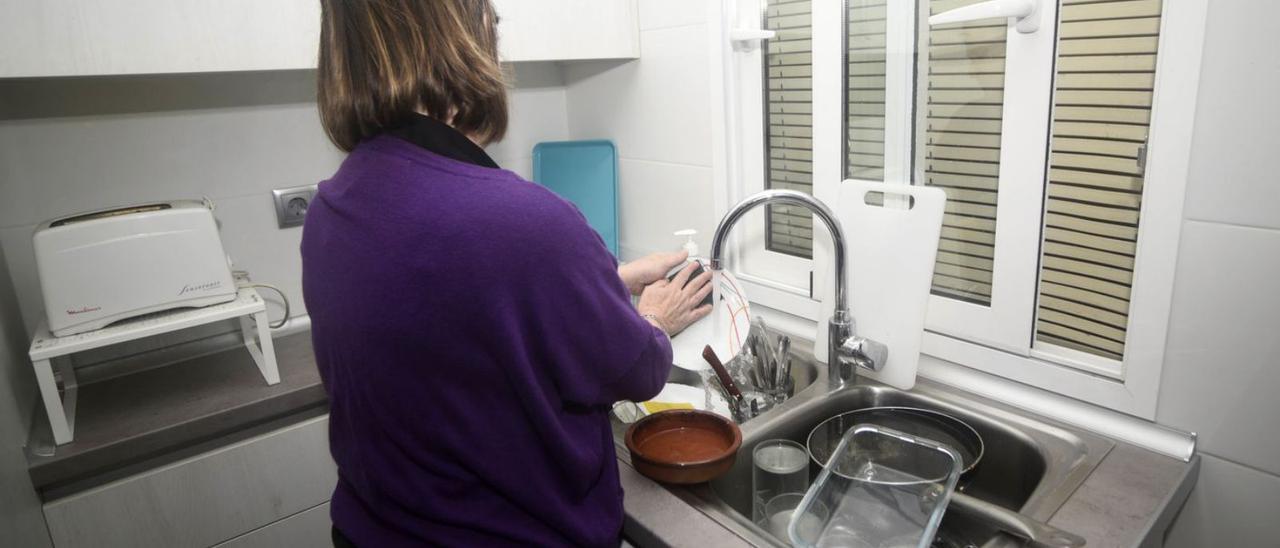 Una mujer realiza labores domésticas en la cocina. | ISRAEL SÁNCHEZ