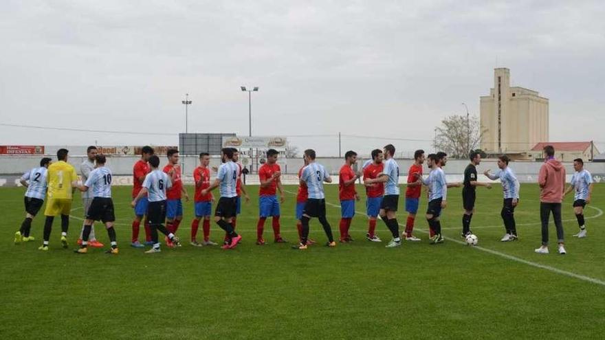 Los jugadores se saludan sobre el césped.